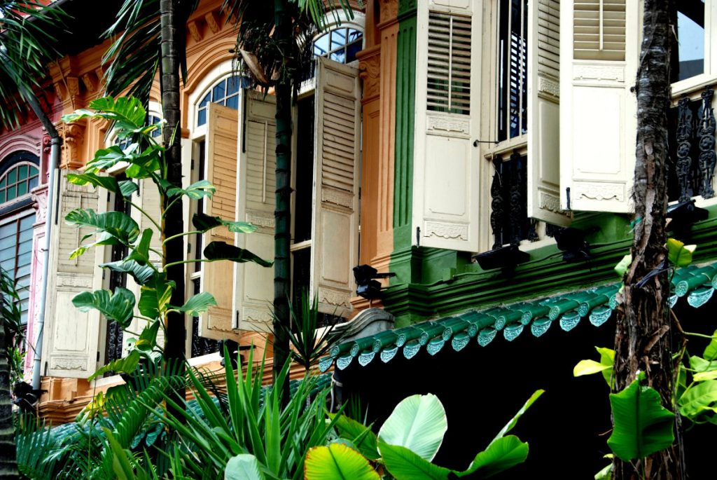 SINGAPORE - Lush tropical foliage and handsome restored Peranakan former shop houses with wooden louvered shutters on Emerald Hill Singapore, December 16, 2007